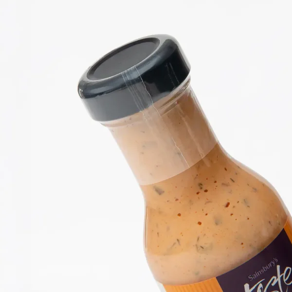 A marinade bottle neck dressed in a heat shrink sleeve