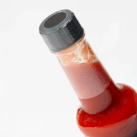 Sauce bottle dressed with a heat shrink sleeve