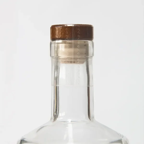 A spirit bottle dressed in a clear heat shrink sleeve